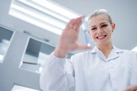 Scientist conducts research in a laboratory while holding a test tube with .. Stockfoto's