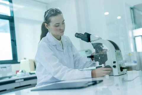 Scientist conducts research using a microscope in a laboratory during daytime Fotos Stock
