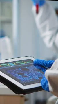Scientist in coverall analyzing virus evolution looking on digital tablet Stock Photos
