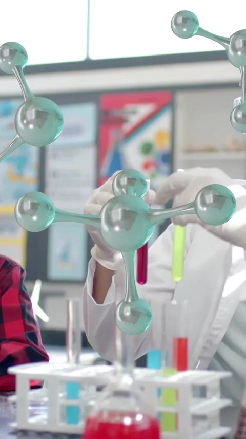 Scientist demonstrating experiment to children over molecular structure Stock Footage 343714380