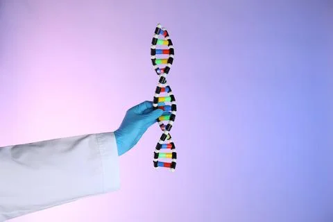 Scientist with DNA structure model on color background, closeup Stock Photos