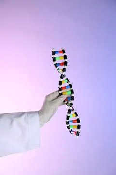 Scientist with DNA structure model on color background, closeup 스톡 사진