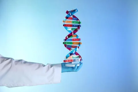 Scientist with DNA structure model on color background, closeup 스톡 사진