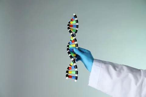 Scientist with DNA structure model on color background, closeup 스톡 사진