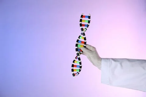 Scientist with DNA structure model on color background, closeup 스톡 사진