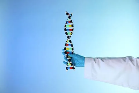 Scientist with DNA structure model on color background, closeup 写真素材