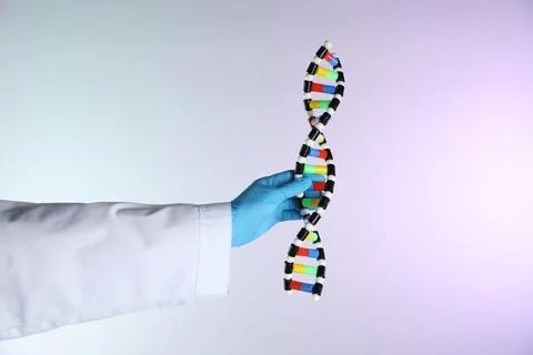 Scientist with DNA structure model on color background, closeup 写真素材