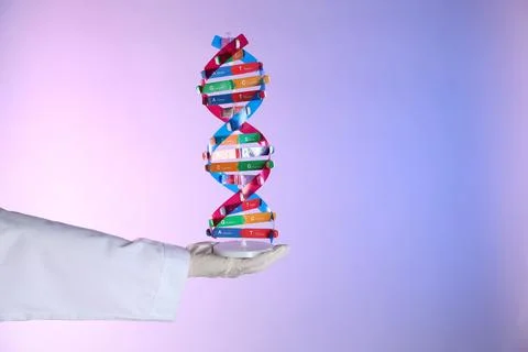 Scientist with DNA structure model on color background, closeup 写真素材