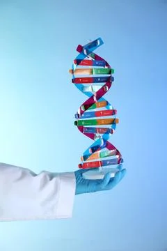 Scientist with DNA structure model on color background, closeup 스톡 사진