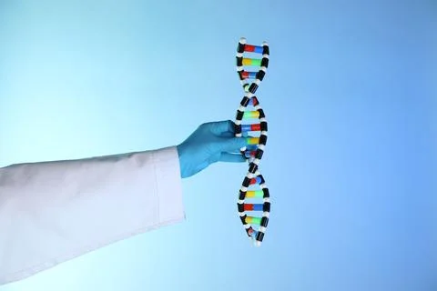 Scientist with DNA structure model on color background, closeup 写真素材