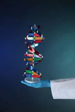 Scientist with DNA structure model on dark blue background, closeup 写真素材