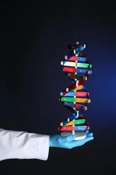 Scientist with DNA structure model on dark blue background, closeup Stock Photos