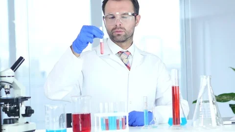 Scientist, Doctor Looking at Red Solution in Test Tube in Laboratory Stock Footage 81165630