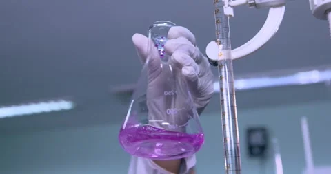 Scientist doing science experiment in a beaker. flask titration with colorful pi Stock Footage 286260394