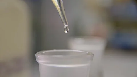 A scientist drips from a dropper pipette into a test tube in the laboratory Stockbeeldmateriaal 275074963
