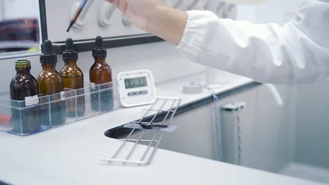 Scientist drop blue liquid to cover glass and start digital timer close up Video stock 158835576