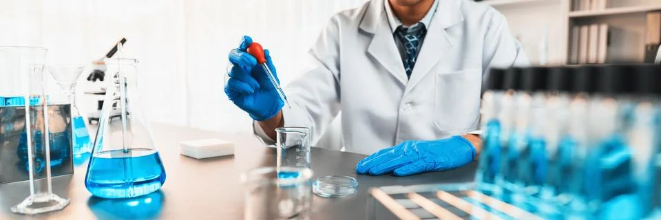 Scientist drop precise amount of liquid from pipette into test tube. Neoteric Stock Photos