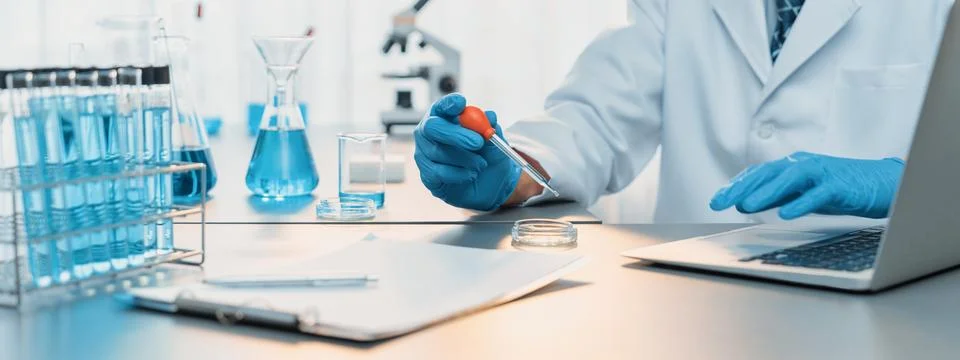 Scientist drop precise amount of liquid from pipette into test tube. Neoteric Stock Photos