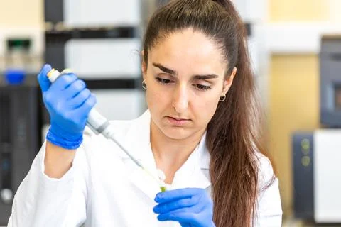 Scientist with dropper dripping liquid into a test tube in scientific laboratory Stock Photos