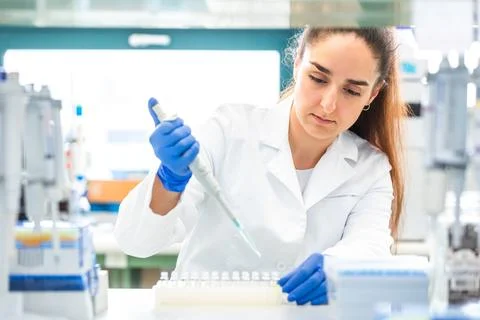 Scientist with dropper dripping liquid into a test tube in scientific laboratory Stock Photos