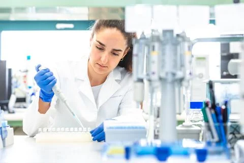 Scientist with dropper dripping liquid into a test tube in scientific laboratory Stock Photos