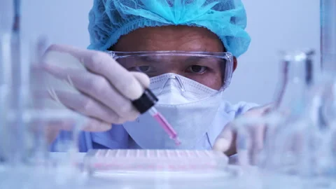 Scientist dropping biochemical solution in to microplate for DNA analysis. Stock Footage 302521178