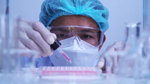 Scientist dropping biochemical solution in to microplate for DNA analysis. Stock Footage 302521279