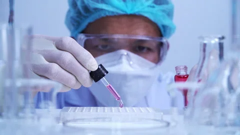 Scientist dropping biochemical solution in to microplate for DNA analysis. Stock Footage 302521722