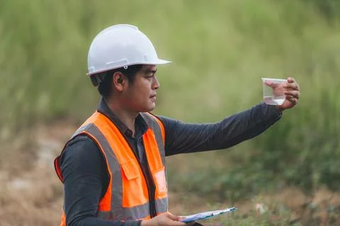 Scientist Ecologist taking a water sample and reading ph value at river. Wa.. Stock Photos