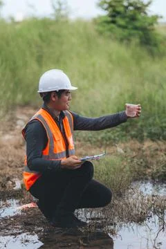 Scientist Ecologist taking a water sample and reading ph value at river. Wa.. Stock Photos