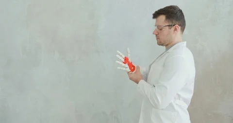 Scientist engineer conducts tests of robotic prosthetic hand trying to move Stock Footage 106222082