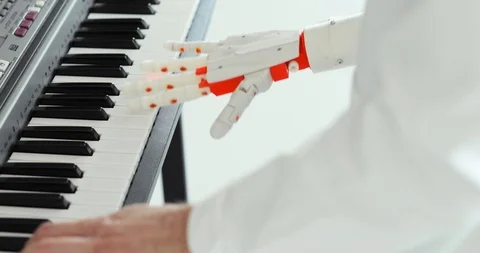 Scientist engineer is playing the piano with robotic prosthesis hand. Playing Stock Footage 106221314