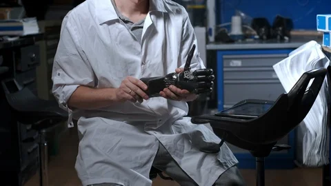 A scientist engineer is testing an electronic bionic prosthetic arm. He moves Stock Footage 120159001