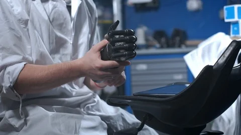 A scientist engineer is testing an electronic bionic prosthetic arm. He moves Stock Footage 120160308