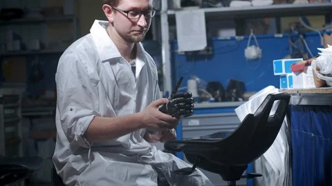 A scientist engineer is testing an electronic bionic prosthetic arm. He moves Stock Footage 120161403