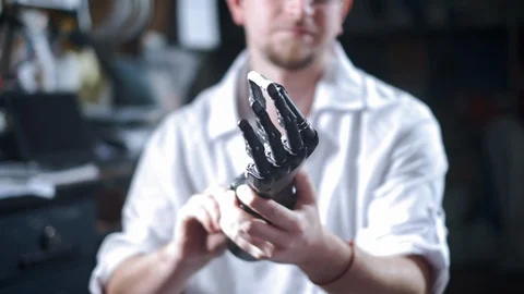 A scientist engineer is testing an electronic bionic prosthetic arm. He moves Stock Footage 120161613