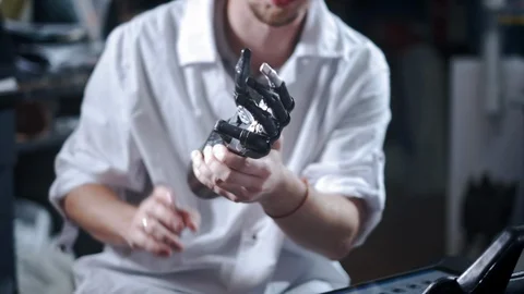 A scientist engineer is testing an electronic bionic prosthetic arm. He moves Stock Footage 120162569