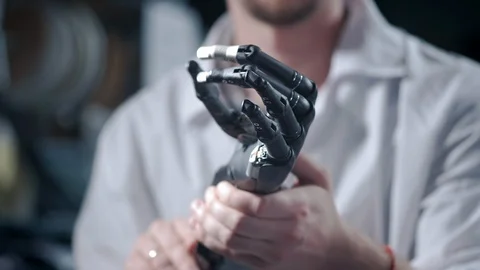 A scientist engineer is testing an electronic bionic prosthetic arm. He moves Stock Footage 120164354