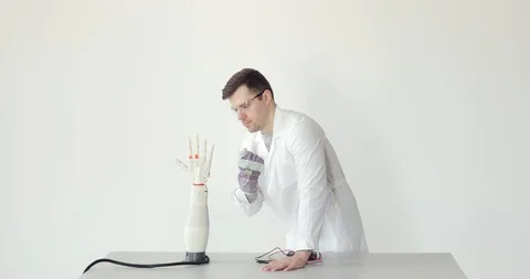 Scientist engineer is testing robotic prosthesis hand which repeats the movement Stock Footage 106220908