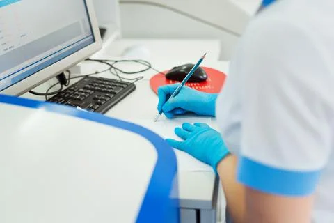 Scientist entering data of blood sample in computer at laboratory Stock Photos