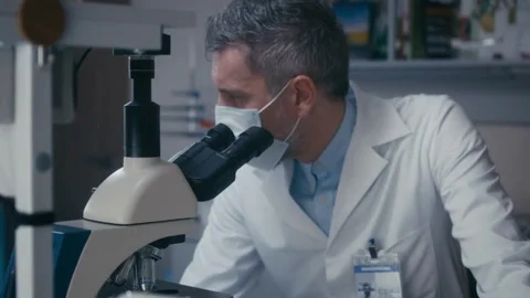 A scientist examines bone cells under a microscope, 2k cinematic footage Stock Footage 336583649