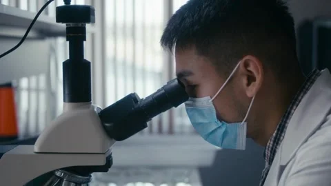 A scientist examines bone cells under a microscope, 2k cinematic footage Stock Footage 336583675