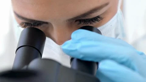 A scientist examines bone cells under a microscope, 2k cinematic footage Stock Footage 336583680