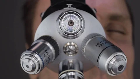 The scientist examines the object under study in a microscope Stock Footage 82722534