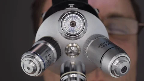 The scientist examines the object under study in a microscope Video stock 82722541