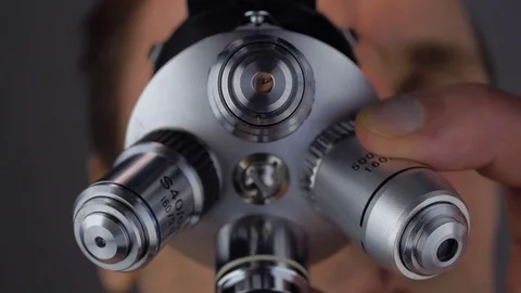 The scientist examines the object under study in a microscope Stock Footage 82787748