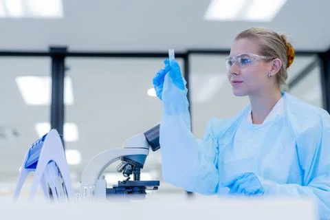 Scientist examines sample using microscope in laboratory during daytime wor.. Stock Photos