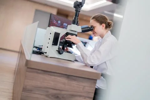 Scientist examines samples through microscope in modern laboratory setting .. Foto stock