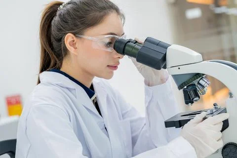Scientist examines samples under microscope in laboratory during work hours Stock Photos