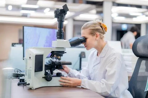 Scientist examines samples using a microscope in a modern laboratory settin.. Stock Photos